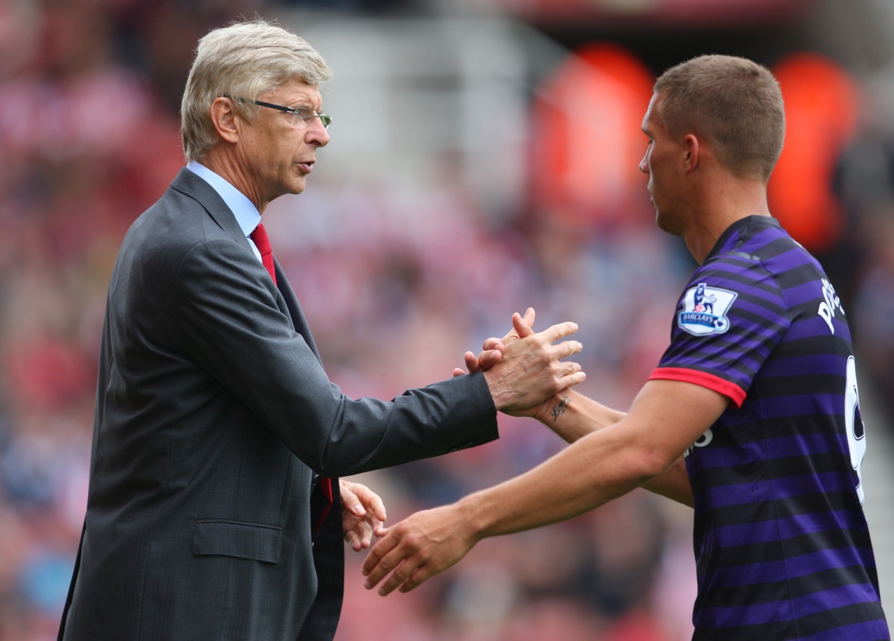 Arsenalin manageri Arsene Wenger Lukas Podolskin kanssa