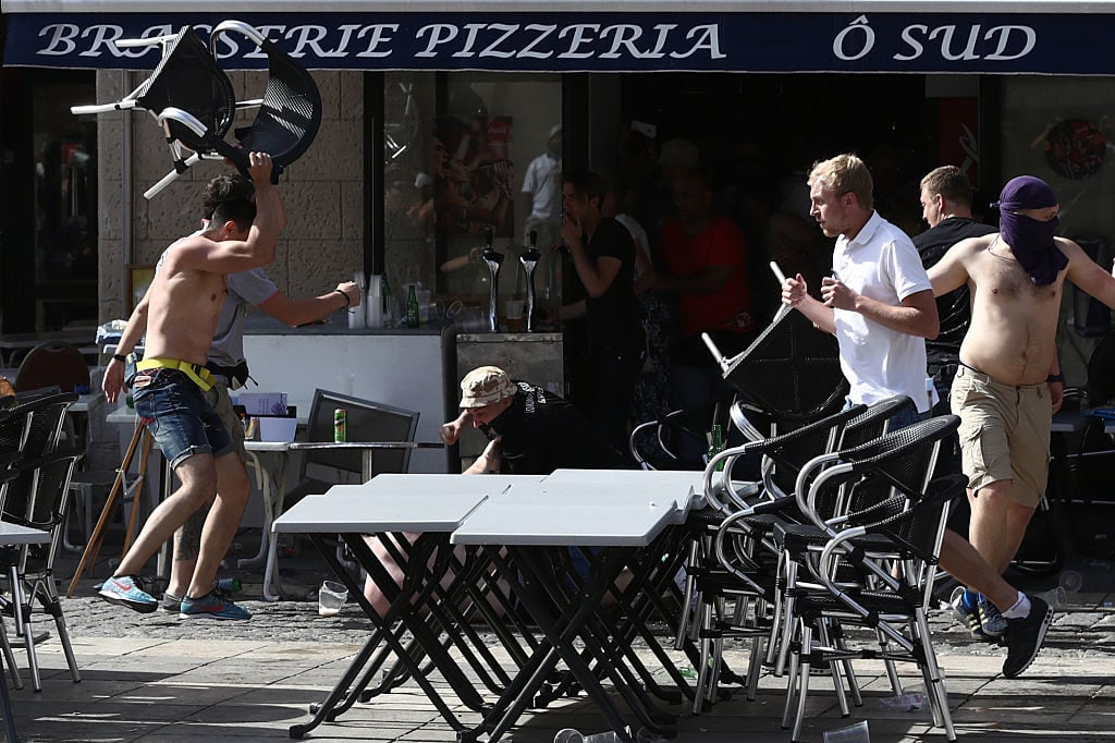 MARSEILLE, FRANCE - JUNE 11:  A Russian fan smashes a chair over an England supporter as another attacks him on the ground as they clash ahead of the game against Russia later today on June 11, 2016 in Marseille, France. Football fans from around Europe have descended on France for the UEFA Euro 2016 football tournament.  (Photo by Carl Court/Getty Images)
