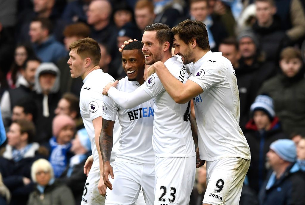 MANCHESTER, ENGLAND - FEBRUARY 05: Gylfi Sigurdsson of Swansea City celebrates scoring his sides first goal with team mates  during the Premier League match between Manchester City and Swansea City at Etihad Stadium on February 5, 2017 in Manchester, England.  (Photo by Stu Forster/Getty Images)
