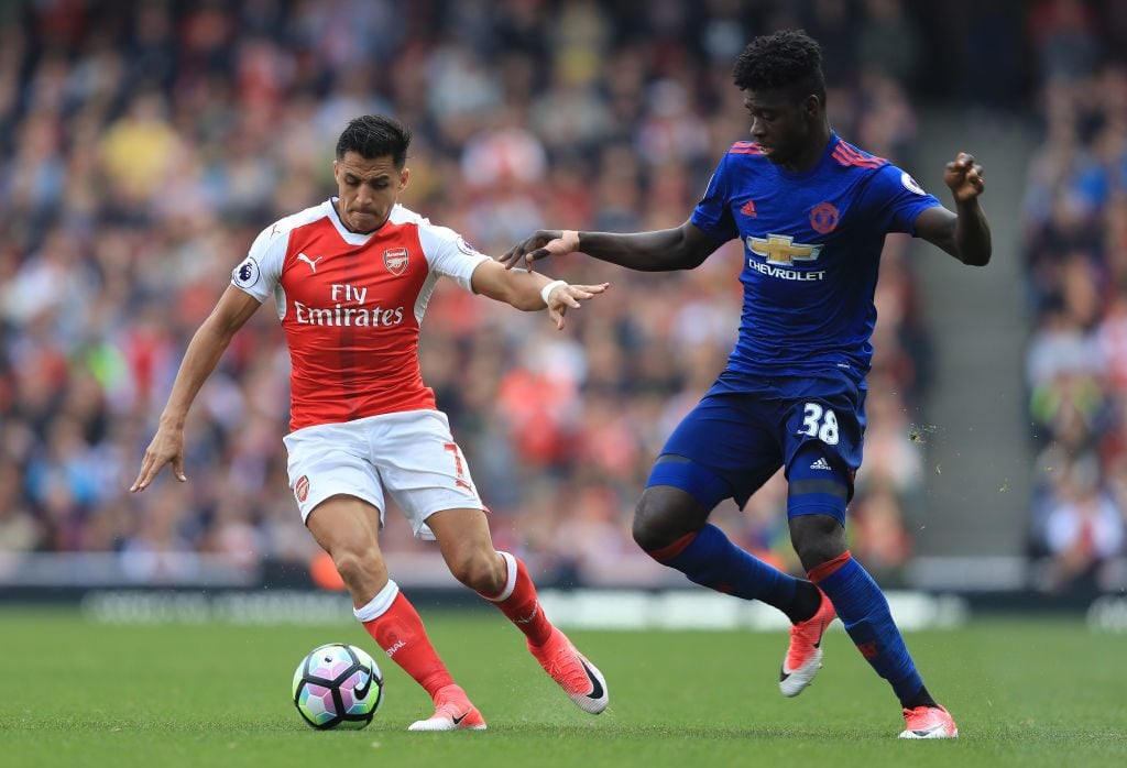 LONDON, ENGLAND - MAY 07: Alexis Sanchez of Arsenal is put under pressure from Axel Tuanzebe of Manchester United during the Premier League match between Arsenal and Manchester United at the Emirates Stadium on May 7, 2017 in London, England. (Photo by Richard Heathcote/Getty Images)