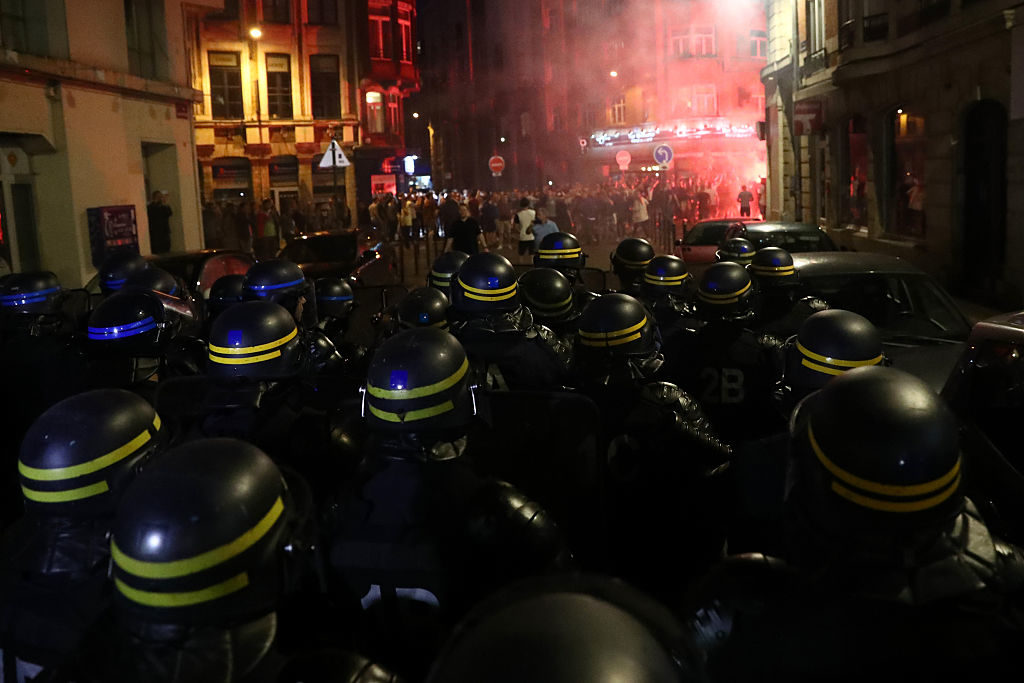 LILLE, FRANCE - JUNE 15:  French riot police march towards drunken English football fans as they clash on June 15, 2016 in Lille, France. Police used tear gas and pepper spray on the fans in a bid to keep public order in the city centre this evening.  (Photo by Carl Court/Getty Images)
