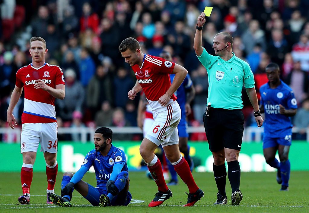 MIDDLESBROUGH, ENGLAND - JANUARY 02: Ben Gibson of Middlesbrough (C) is shown a yellow card by referee Robert Madley for a proffesional foul on Riyad Mahrez of Leicester City (L) during the Premier League match between Middlesbrough and Leicester City at Riverside Stadium on January 2, 2017 in Middlesbrough, England.  (Photo by Matthew Lewis/Getty Images)
